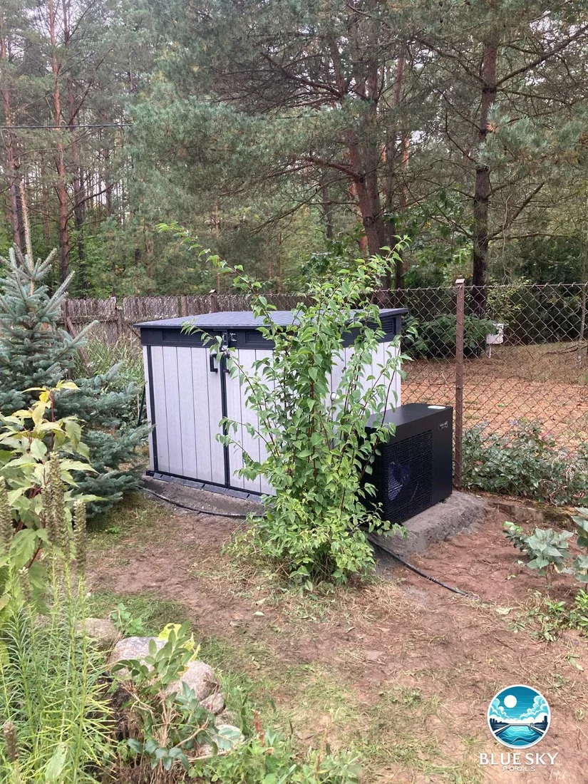 Pompa ciepła Fairland i obudowa techniki basenowej w ogrodzie obok basenu betonowego