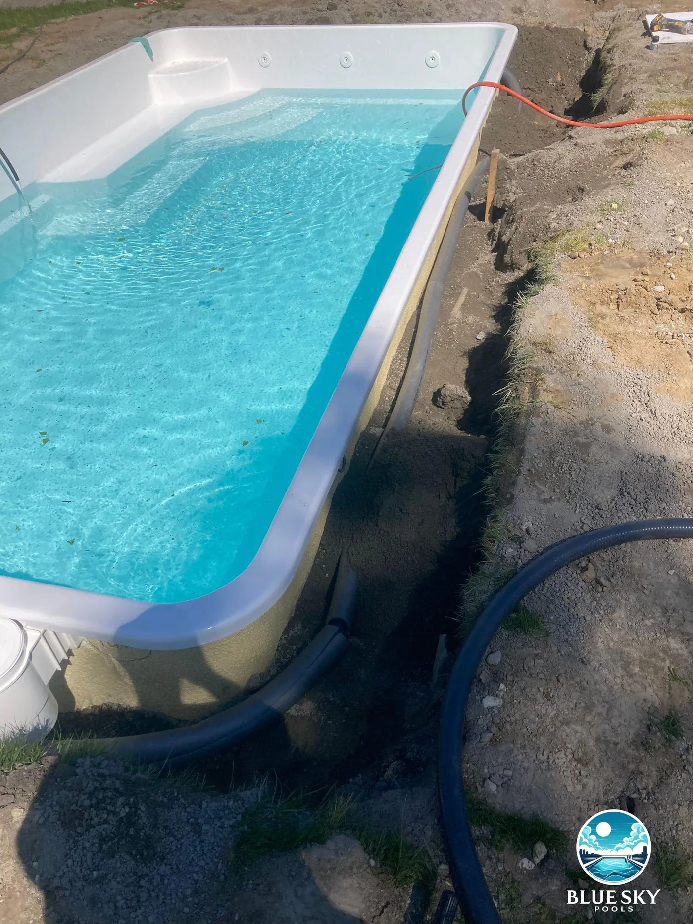 Basen betonowy z niebieską folią podczas instalacji techniki basenowej z pompą ciepła Fairland