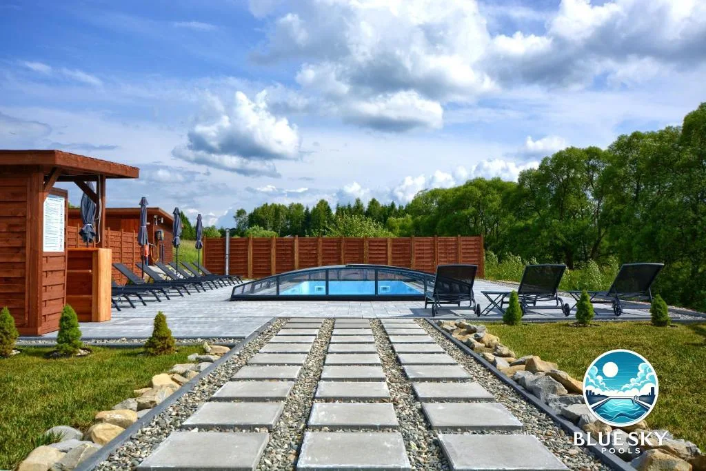 Basen betonowy z niskim zadaszeniem, betonowy pomost i drewniana sauna