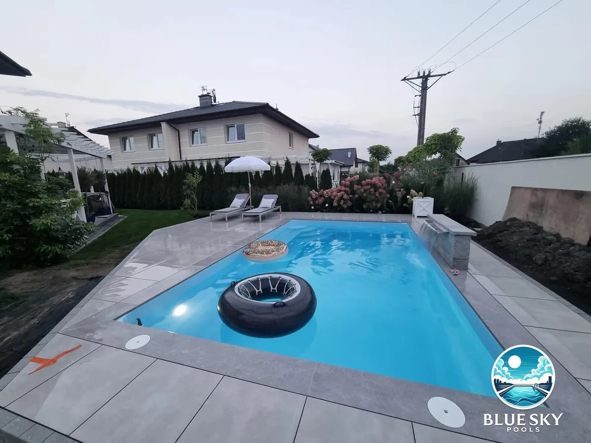 Basen betonowy z kołami ratunkowymi, taras z płyt betonowych i zadaszenie